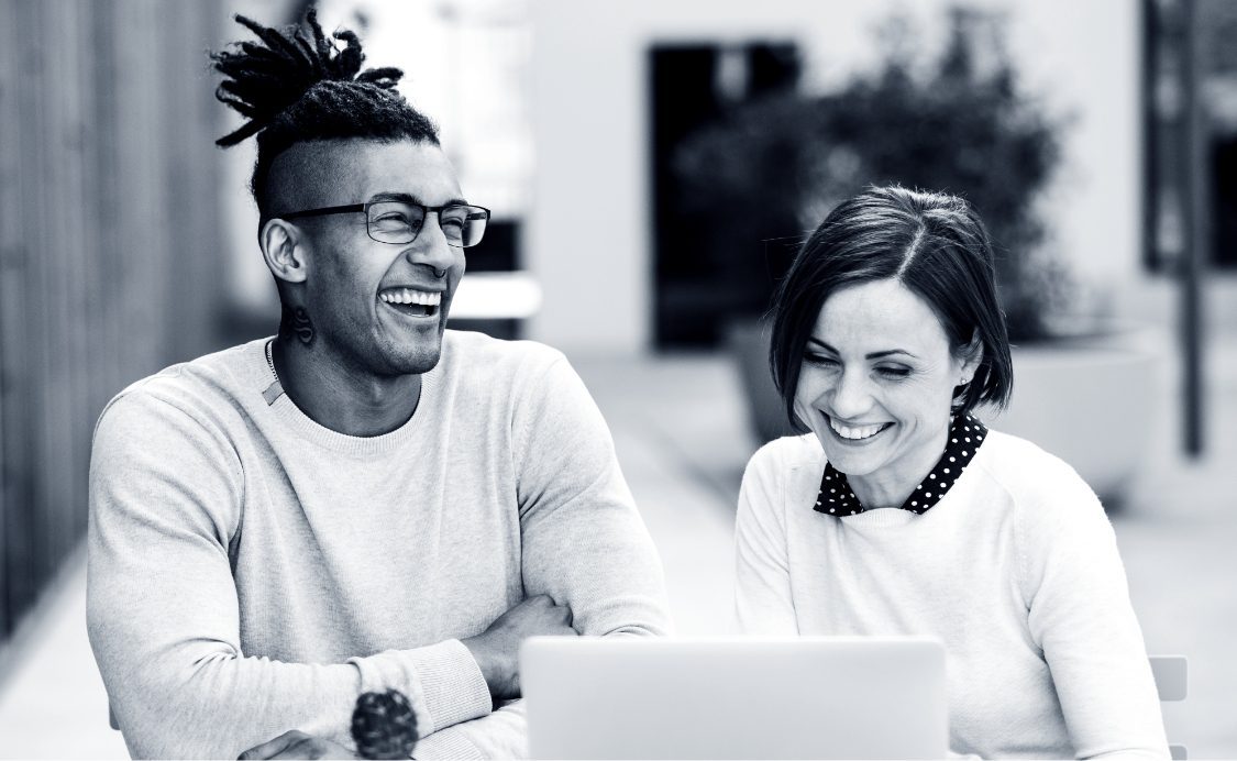 Two happy people working on a laptop